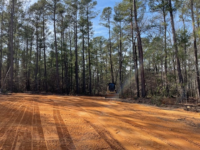Excavator loading tree debris into dump truck in active logging area